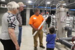 Adam Roelfs Public Works Superintendent shows people one of the cartridge filters used in the osmosis system during open house at the new water treatment facility held Wednesday.