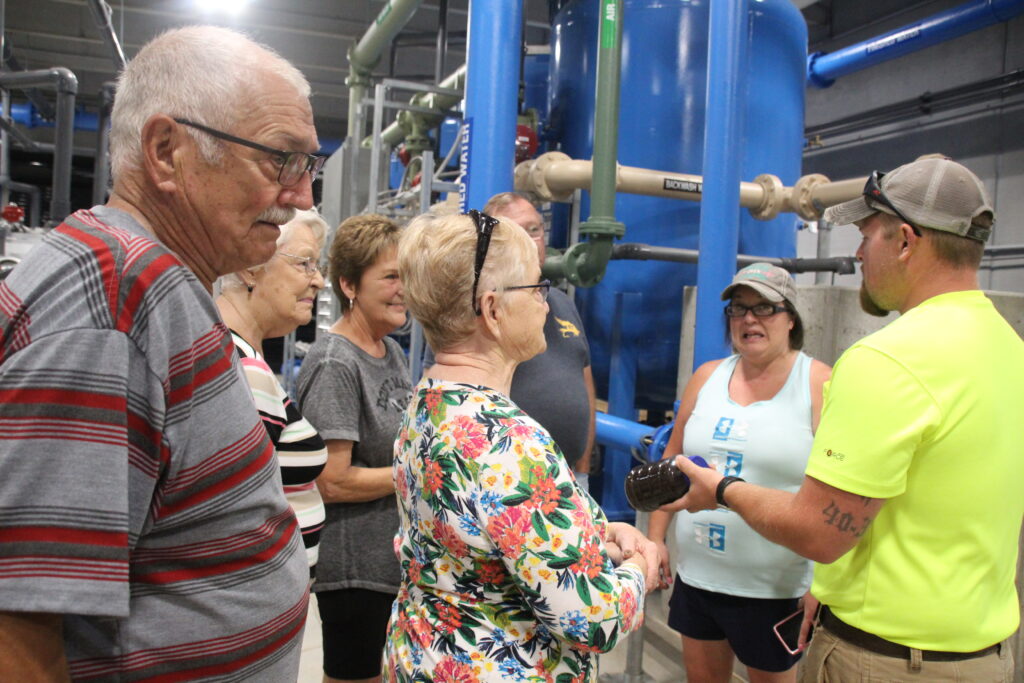 Travis Enger shows people some unfiltered water during the open house at the new water treatment facility.