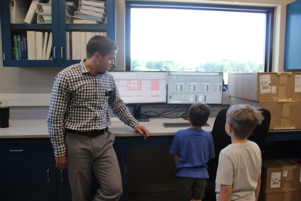 These youngsters ask Ryan Norman from DGR Engineering about what the computers monitor during the Open House with guided tour at the new water treatment facility.
