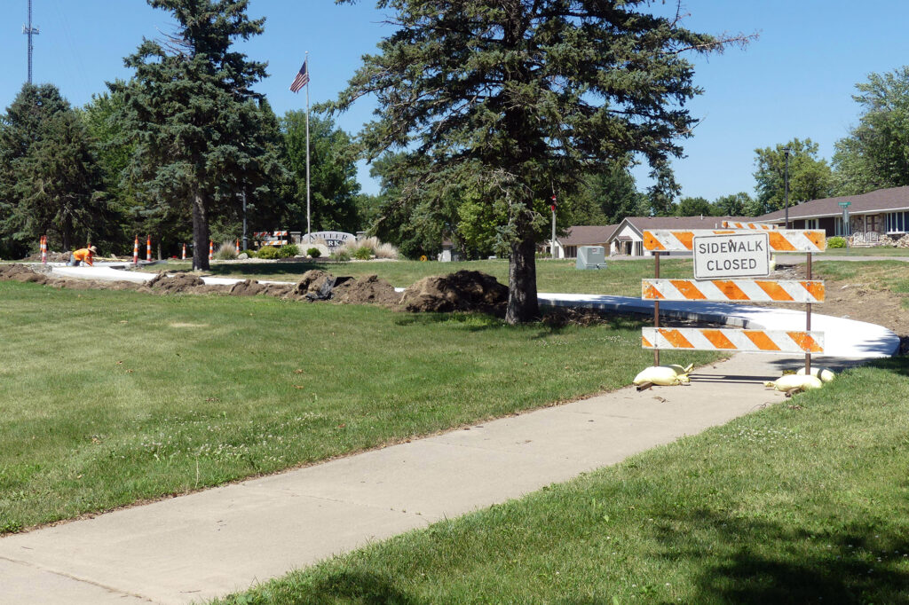 Where the trail used to open onto Sanborn Street it now crosses Hubert H. Schultz Blvd. at the point where the worker is visible.