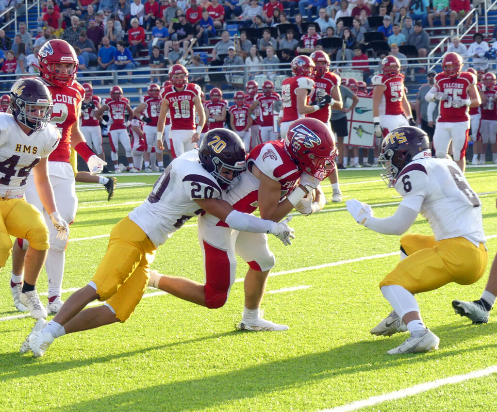 Trenton Vollink prepares to tackle West Sioux receiver Mason Coppock head-on while Ryan Borden grabs on from the rear.