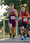 Aiden Bush (125) crosses the bridge over Mill Creek, a feature of the course laid out at Paullina Golf Club for the Wolverine Cross Country Invite.