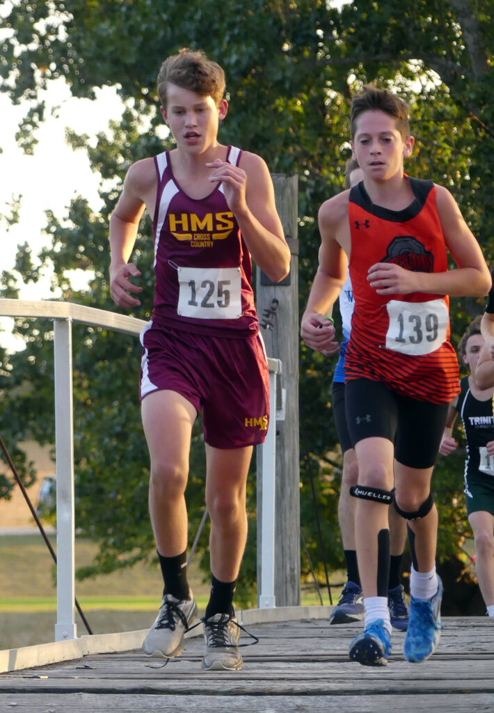 Aiden Bush (125) crosses the bridge over Mill Creek, a feature of the course laid out at Paullina Golf Club for the Wolverine Cross Country Invite.